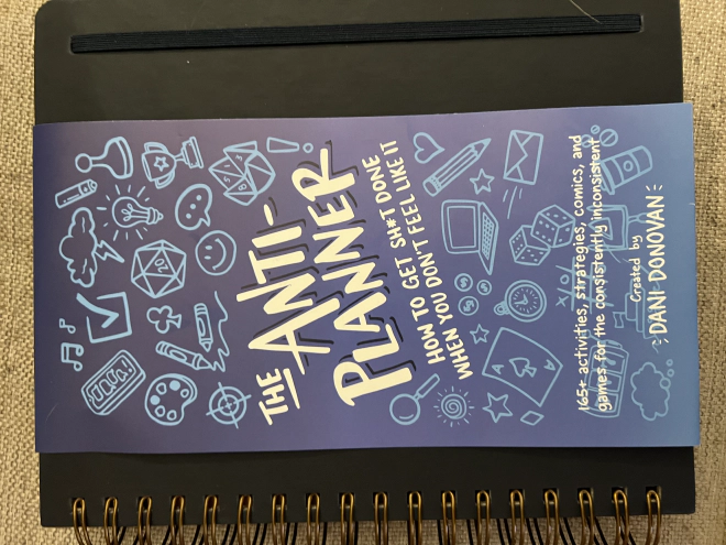 Thick workbook with label wrapped around cover showing that this is the Anti-Planner by Dani Donovan