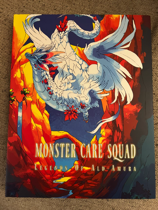 Cover of Monster Care Squad showing a beautiful dragon like creature flying between two mountainsides.